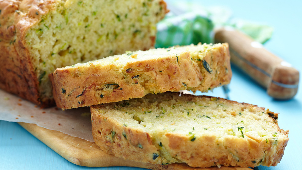 Zucchinibrot in Kastenform angeschnitten auf Holzbrett