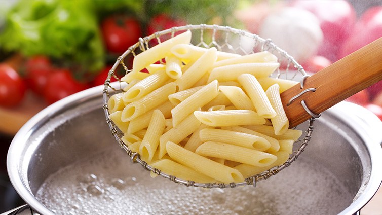 Pasta kochen mit Schaumkelle und Topf