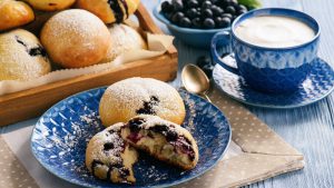 Quarkbrötchen mit Blaubeeren aufgebrochen auf einem Teller