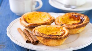 Pasteis de Nata auf Teller mit Kaffee und Zimt