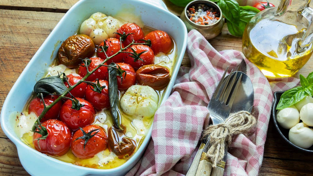 Gebackene Tomaten mit weiteren Zutaten in einer Auflaufform.