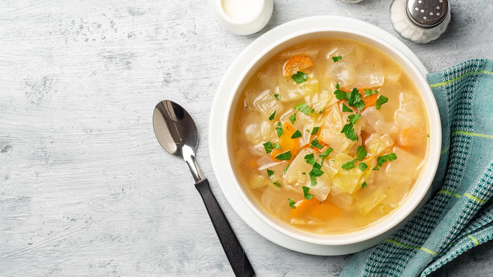 Kohlsuppe in einer Schüssel mit Löffel.