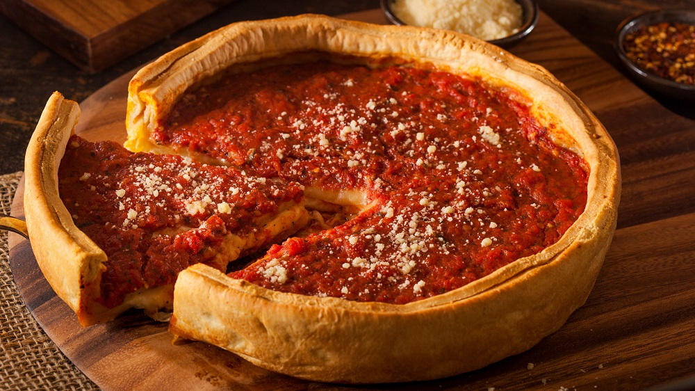 Chicago Style Deep Dish Pizza auf einem Brett.