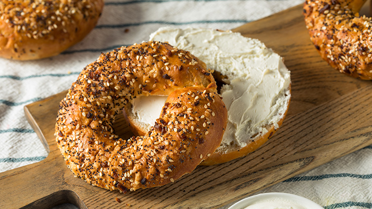 Aufgeschnittener Bagel mit Frischkäse bestrichen